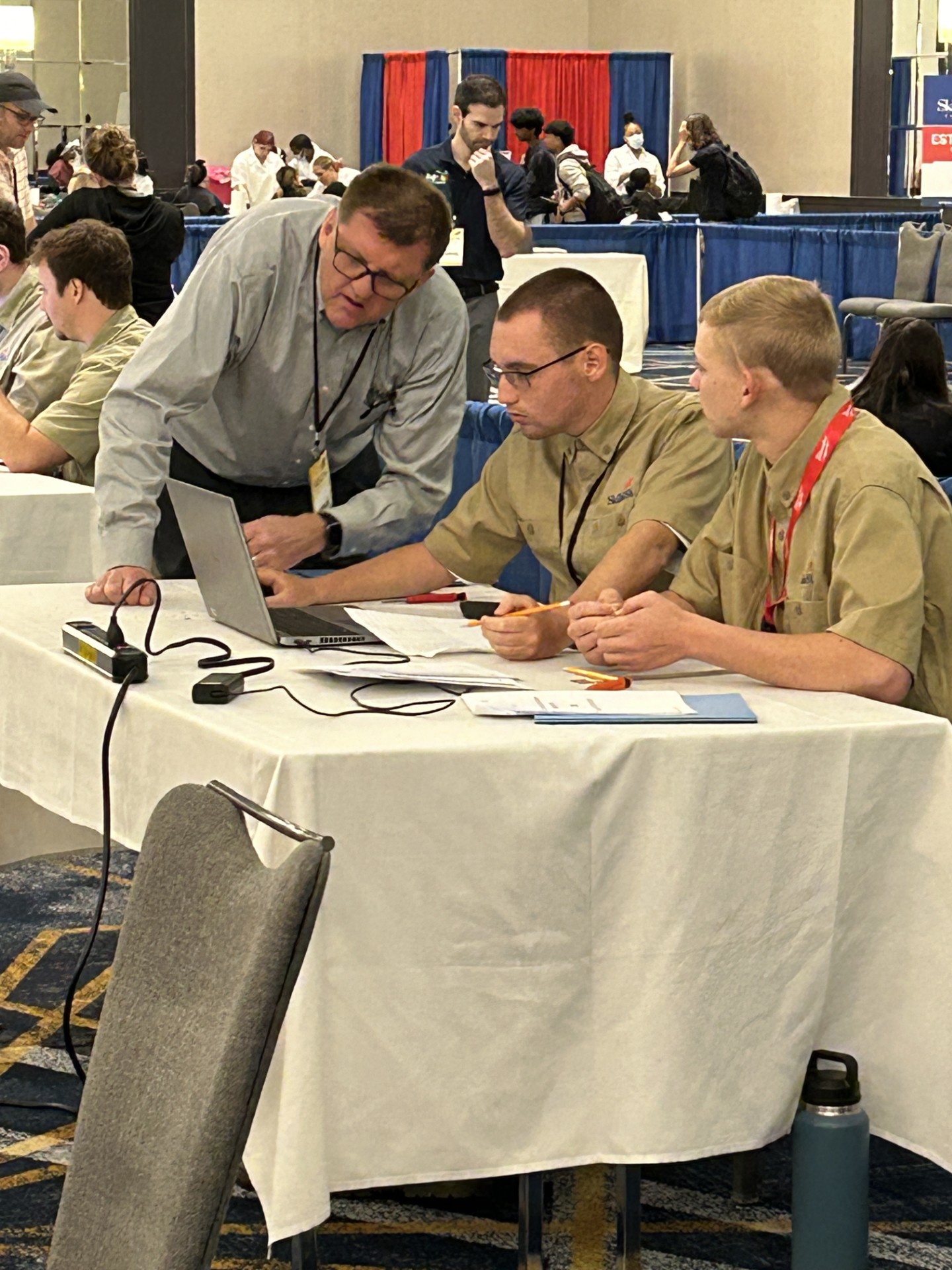 A group of men looking at a computerDescription automatically generated